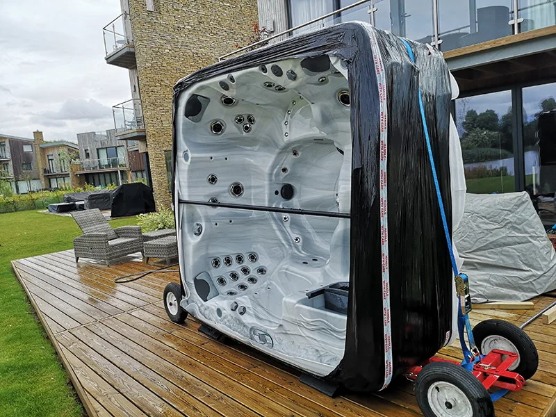 A hot tub secured upright on wheeled moving equipment